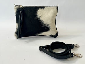 Small cowhide convertible clutch in black and white hair on hide with removable strap handmade in Charlotte NC by Marge and Rudy