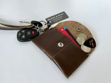 Load image into Gallery viewer, Handcrafted genuine leather keychain wallet with wristlet strap in brown shown open with keys attached and cards, coins and guitar pick inside.