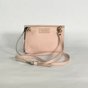 back side of pink leather purse showing makers logo