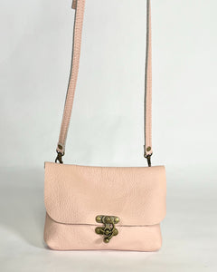 pink leather purse with crossbody strap and antique brass front clasp