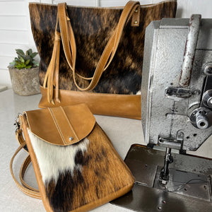 Studio shot of handmade leather bags near industrial sewing  machine